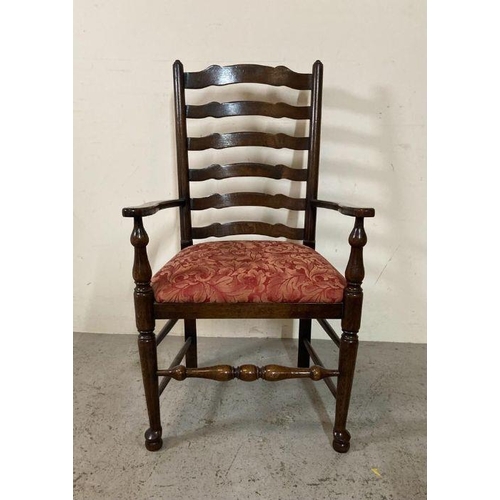 208 - An oak spool turned ladder back arm chair upholstered in red