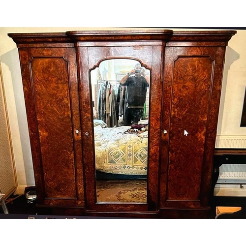 216 - A Victorian burr walnut triple wardrobe. A breakfront shape top cornice above three doors, two with ... 