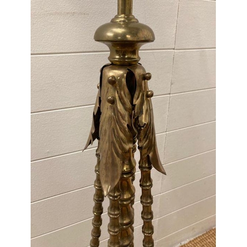 249 - A Victorian brass floor standing oil lamp on four legs with foliate details