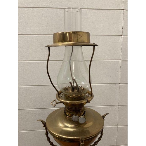 249 - A Victorian brass floor standing oil lamp on four legs with foliate details