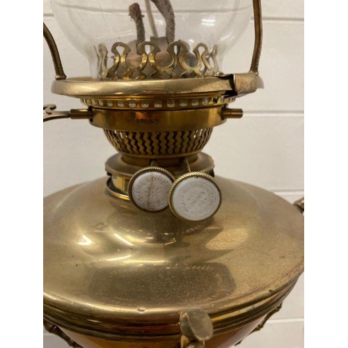 249 - A Victorian brass floor standing oil lamp on four legs with foliate details