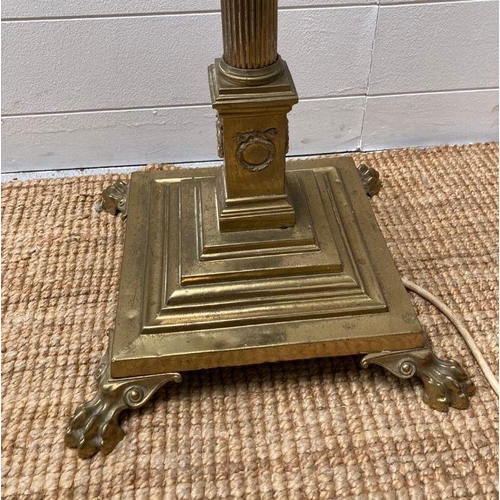 250 - A brass Corinthian column floor standing lamp on a square base with lion paw feet