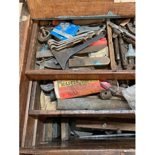 304 - A large vintage wooden steal banded tool box with cast iron handles containing and extensive collect... 