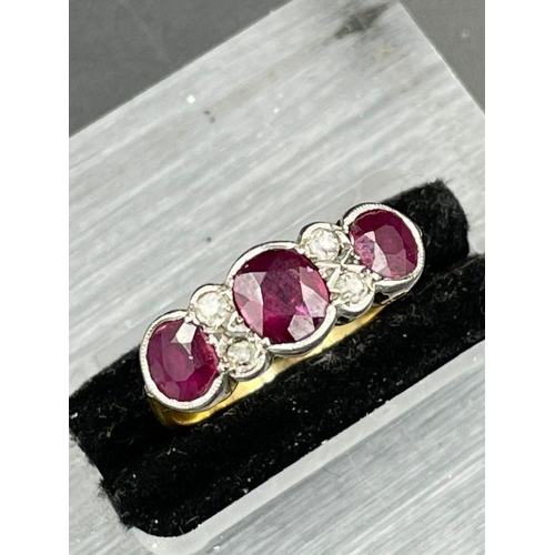 479 - An Antique three stone ruby ring with four small diamonds. Size K