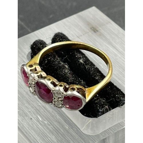 479 - An Antique three stone ruby ring with four small diamonds. Size K