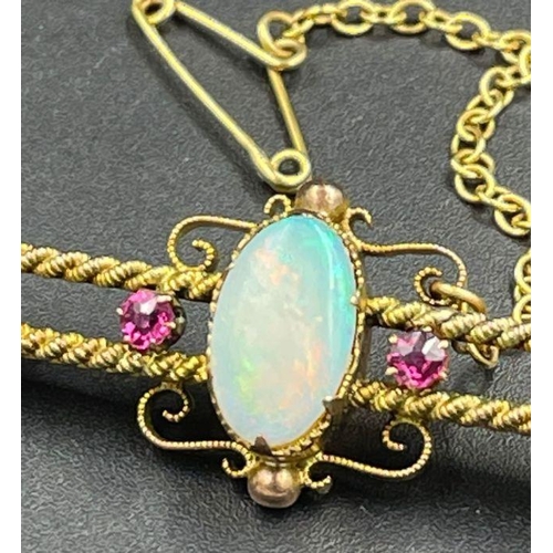 484 - An Opal and ruby brooch in a gold setting AF