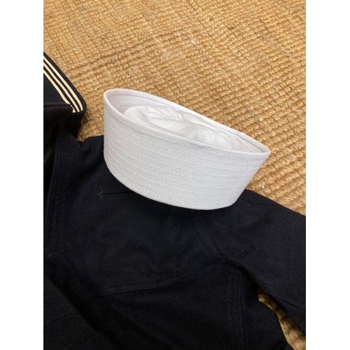 581 - A US Naval uniform to include hats, tunic and trousers