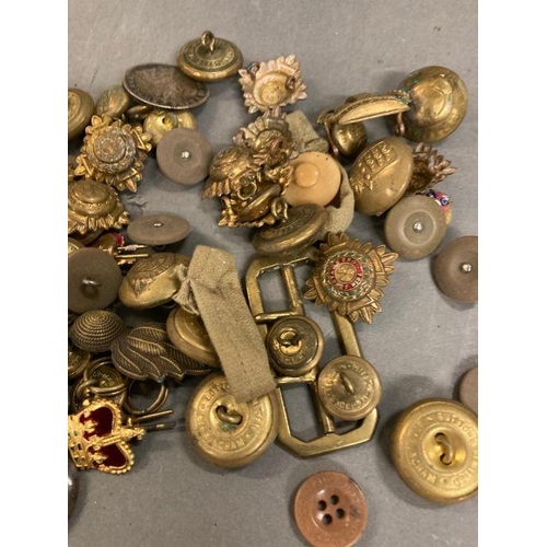 583 - A selection of military buttons, insignia and cap badges