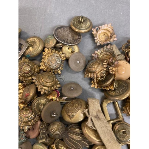 583 - A selection of military buttons, insignia and cap badges