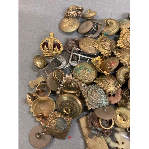 583 - A selection of military buttons, insignia and cap badges