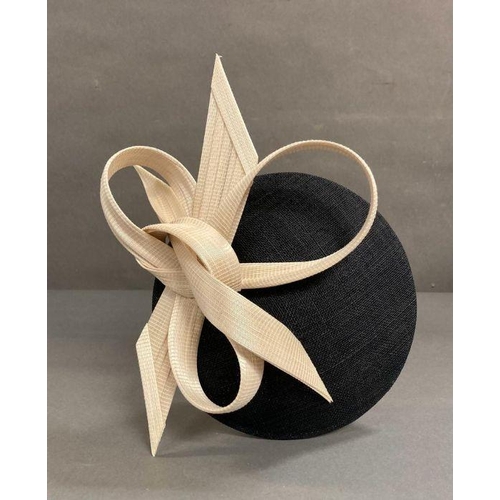 607 - A black fascinator with a cream hard sculped twist by Philip Treacy