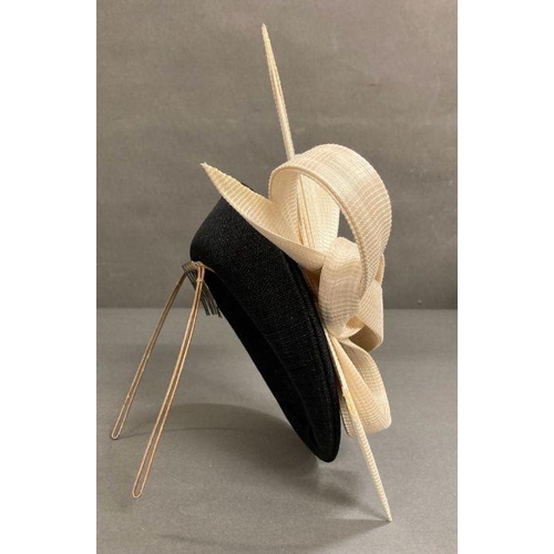 607 - A black fascinator with a cream hard sculped twist by Philip Treacy