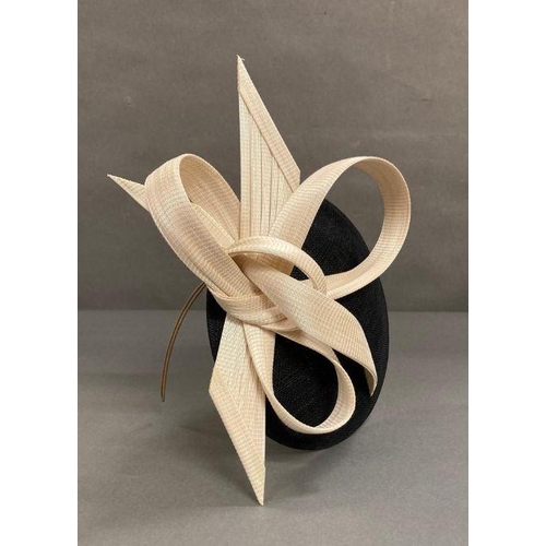 607 - A black fascinator with a cream hard sculped twist by Philip Treacy