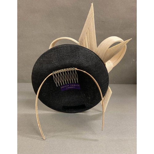 607 - A black fascinator with a cream hard sculped twist by Philip Treacy