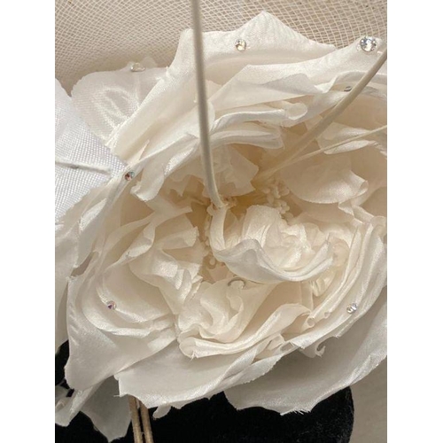 609 - A champagne saucer fascinator with feather and satin rose trim