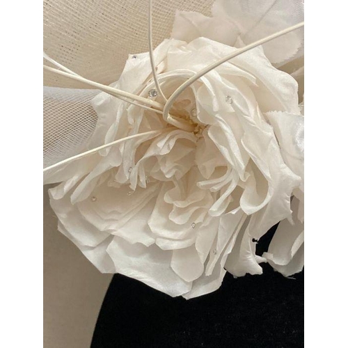 609 - A champagne saucer fascinator with feather and satin rose trim