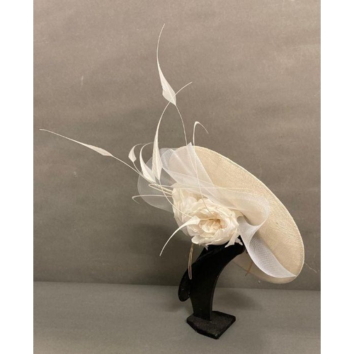 609 - A champagne saucer fascinator with feather and satin rose trim