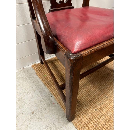 64 - An early 19th Century mahogany arm chair with pierced splat back over dropping leather seat