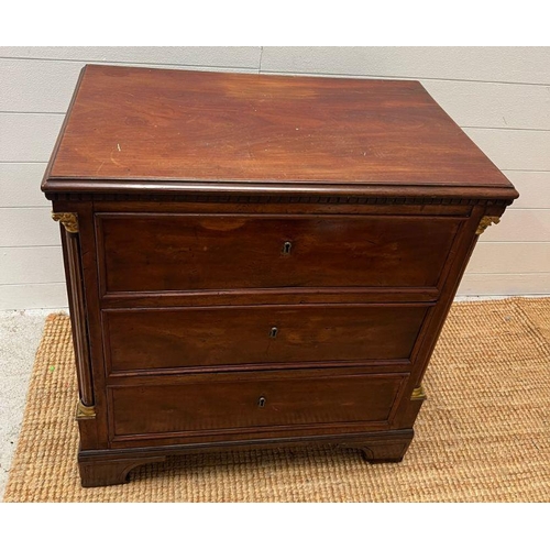 65 - An early 19th Century empire mahogany chest of three drawers, having fluted columns and gilt mefu ca... 