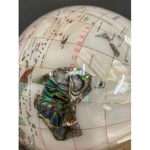 671 - A rotating cradle globe of Gemstone and Lapis