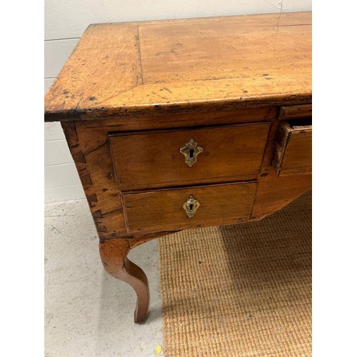 68 - An early 19th Century fruit wood provincial desk having an arrangement of five drawers on slight cab... 