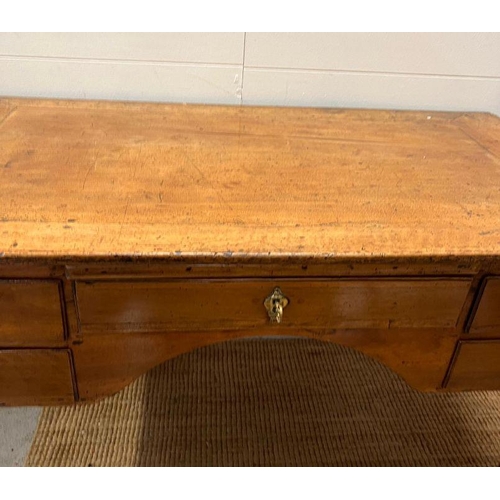 68 - An early 19th Century fruit wood provincial desk having an arrangement of five drawers on slight cab... 