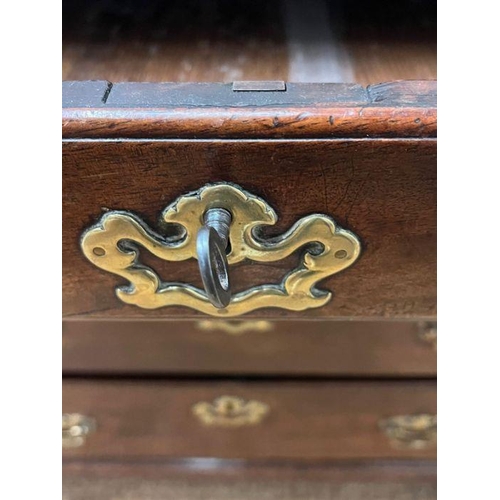 70 - A George III bureau, the fall front enclosing drawers and recesses around a central door along with ... 