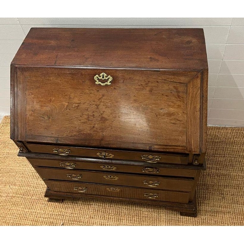 70 - A George III bureau, the fall front enclosing drawers and recesses around a central door along with ... 