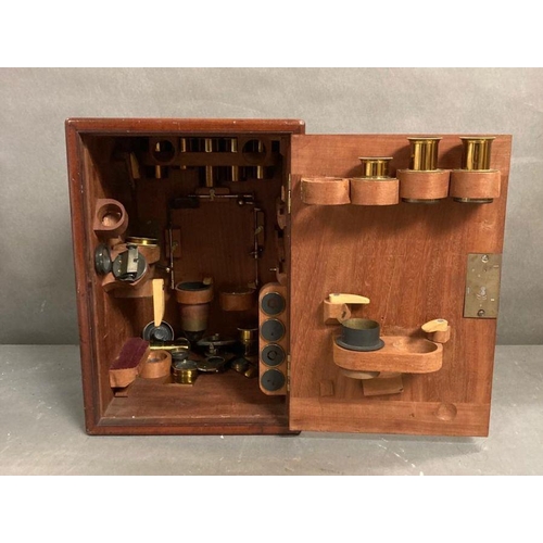 723 - A 19th Century Wenham binocular petrological microscope by Ross of London, cased on plinth in a glas... 