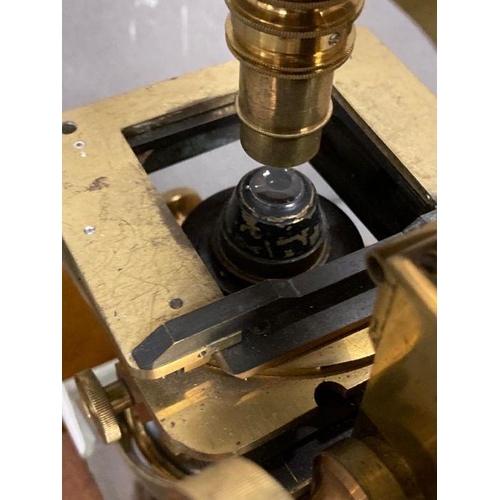 723 - A 19th Century Wenham binocular petrological microscope by Ross of London, cased on plinth in a glas... 