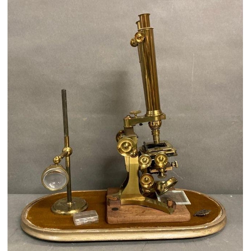 723 - A 19th Century Wenham binocular petrological microscope by Ross of London, cased on plinth in a glas... 