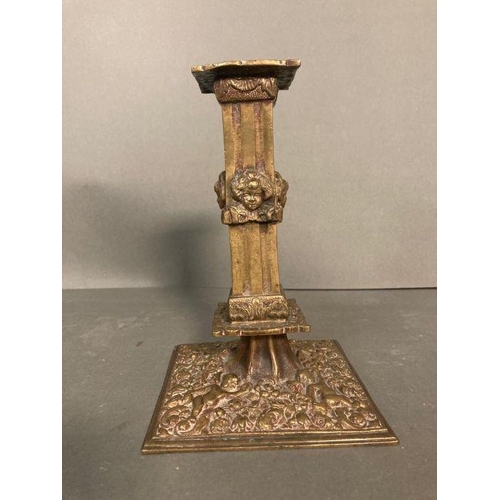 121 - A Victorian style brass candle holder with cherubs to base and stem