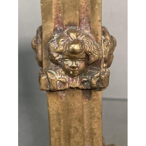 121 - A Victorian style brass candle holder with cherubs to base and stem