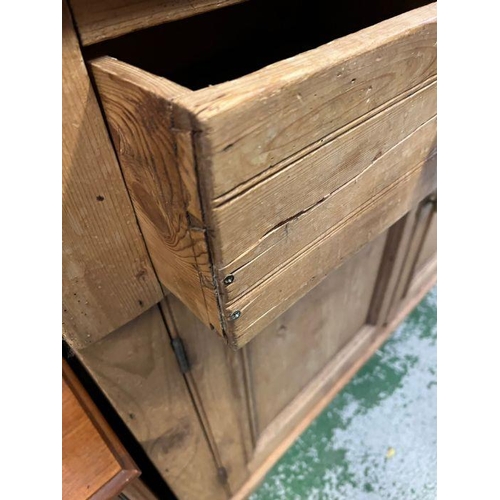 28 - An antique pine glazed dresser, the glazed top hinged doors opening to shelves and a cupboard base w... 