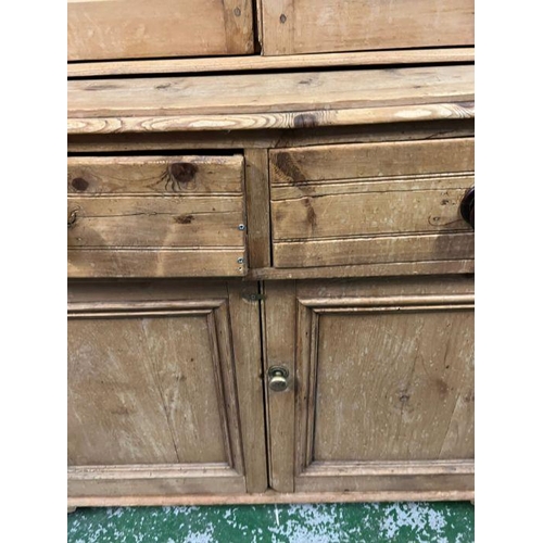 28 - An antique pine glazed dresser, the glazed top hinged doors opening to shelves and a cupboard base w... 