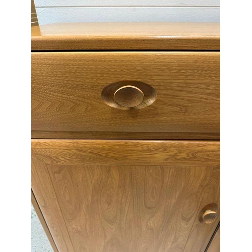 30 - An Ercol sideboard with three drawers and three cupboards under