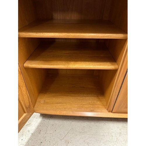 30 - An Ercol sideboard with three drawers and three cupboards under