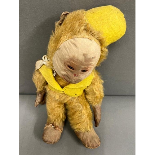 42 - A vintage monkey with jointed arms and legs, leather hands and feet wearing a yellow felt hat and wa... 