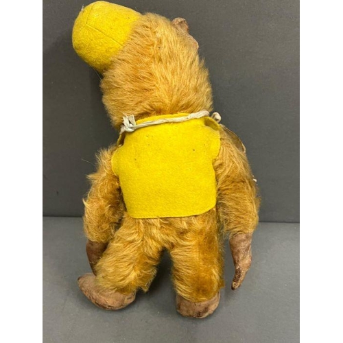 42 - A vintage monkey with jointed arms and legs, leather hands and feet wearing a yellow felt hat and wa... 