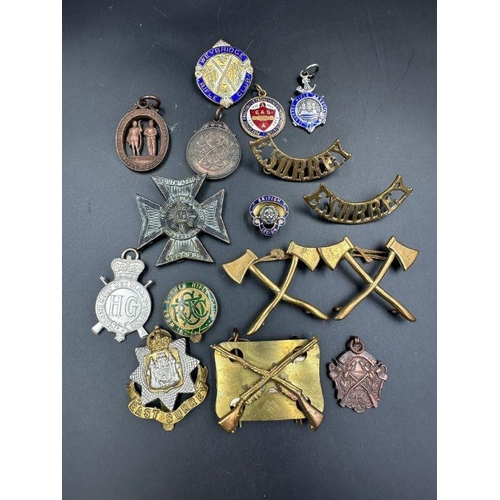 646 - A selection of military insignia and rifle club badges.