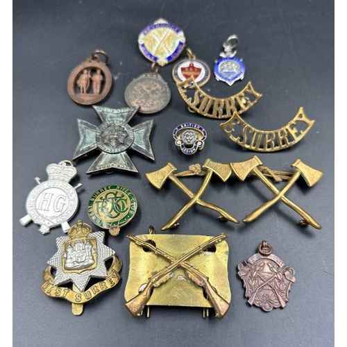 646 - A selection of military insignia and rifle club badges.