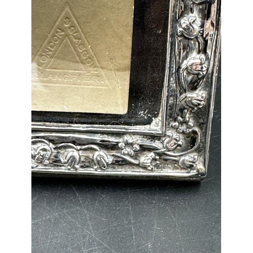 84 - A good Art Nouveau silver embossed photograph frame, Birmingham 1901, together with period 1915 sepi... 