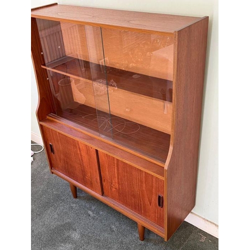 24 - A Mid Century teak display unit, sliding doors to top on tapering legs (H118cm W91cm D29cm)