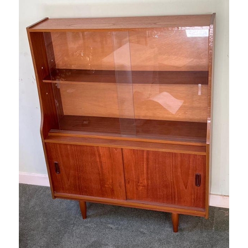24 - A Mid Century teak display unit, sliding doors to top on tapering legs (H118cm W91cm D29cm)