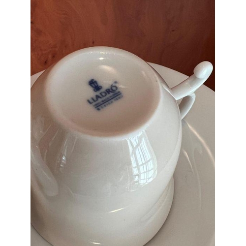 255 - A Lladro cup and saucer with cats playing to side