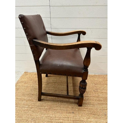 4 - An oak brown leather studded upholstered open armchair on carved legs