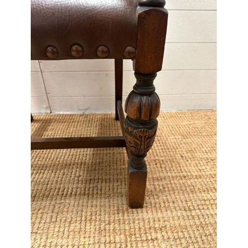 4 - An oak brown leather studded upholstered open armchair on carved legs