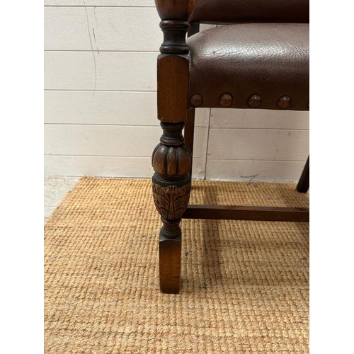 4 - An oak brown leather studded upholstered open armchair on carved legs