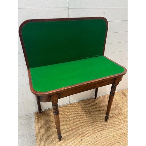 41 - A mahogany card table on turned legs (H75cm W92cm D44cm)