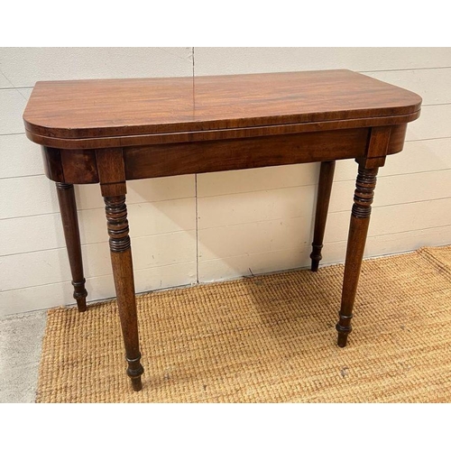 41 - A mahogany card table on turned legs (H75cm W92cm D44cm)